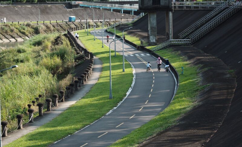 people driving on bike lane along riverba